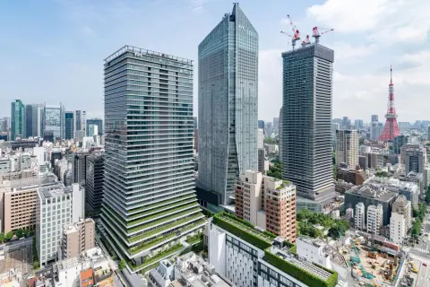 Nowoczesne wieżowce i Tokio Tower w Japonii. W tle widać plac budowy z dźwigami.