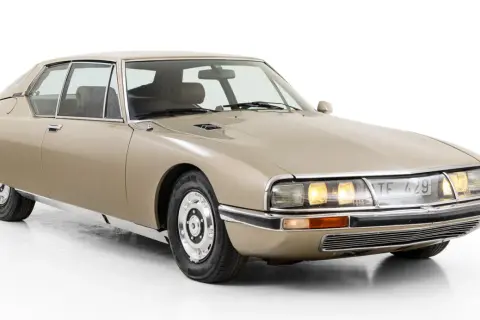 En beige Citroën SM, en av många ikoniska Citroën modeller, med sina distinkta linjer och strålkastare.