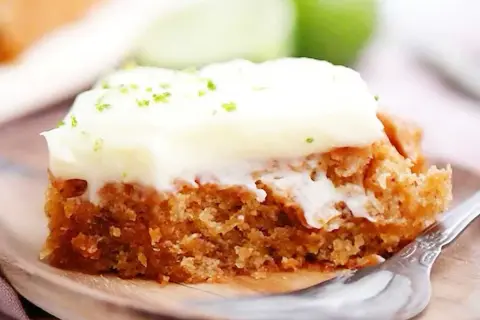 En saftig bit vegansk morotskaka med krämig frosting och rivet limeskal.