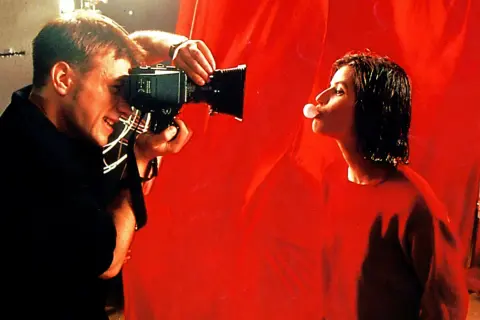 Reżyser kręci scenę do najlepszego filmu w historii. Aktorka dmucha bańkę z gumy.
