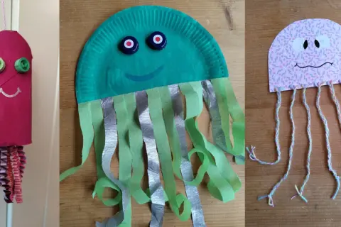 Drei bunte Quallen zum Basteln: eine aus einer Toilettenpapierrolle, eine aus einem Pappteller und eine aus Papier mit Garn.
