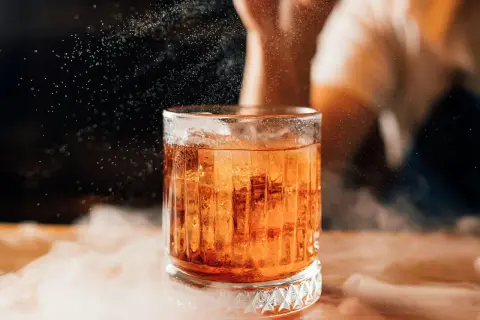 Elegancki boulevardier z lodem, otoczony mgiełką, w blasku światła.