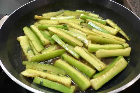Tranches de concombre cuit dans une poêle, prêtes pour une recette savoureuse.