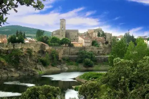 Pueblo amurallado con río y vegetación exuberante. ¡Ideal para saber qué hacer hoy en la sierra de Madrid!