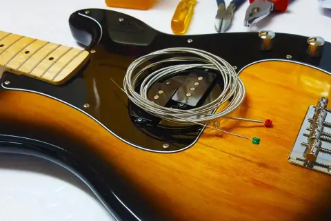 Nowe struny czekają na założenie na gitarę. Zobacz, jak łatwo to zrobić!