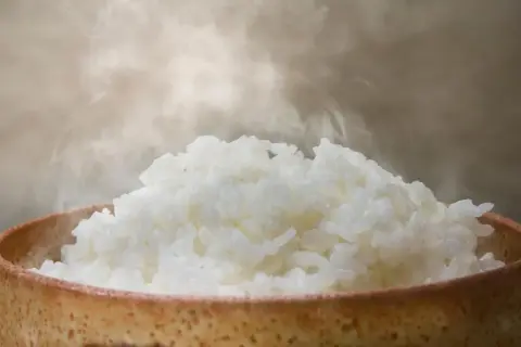 Heißer, dampfender Reis in einer Schale. Man fragt sich, wann ist Reis fertig, wenn er so frisch aussieht.