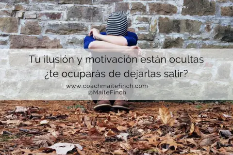 Persona sentada contra pared de piedra, con hojas secas en el suelo. El texto pregunta: "¿Qué es la motivación? Tu ilusión y motivación están ocultas. ¿Te ocuparás de dejarlas salir?".