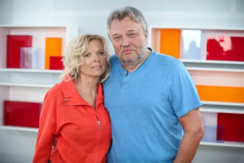 Krzysztof Cugowski z żoną, Beatą, pozują do zdjęcia na tle kolorowych półek.