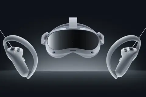 Pico 4 Test: VR-Headset mit zwei Controllern in schwebender Darstellung vor dunklem Hintergrund.