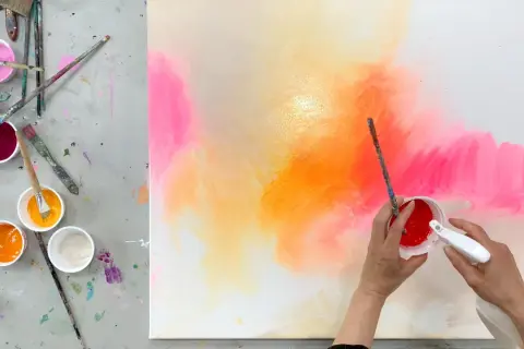 Bunte Farben auf einer Leinwand, bereit zum leinwand bemalen mit kindern. Pinsel und Becher mit Farbe liegen bereit.