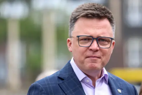 Szymon Hołownia w okularach, w garniturze. Mówi się o jego chorobie, ale wygląda na siłach.