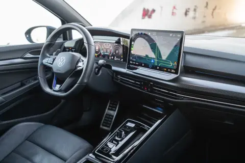 Wnętrze **Golf R 2025** z cyfrowymi zegarami i dużym ekranem nawigacji. Sportowa kierownica i eleganckie detale.