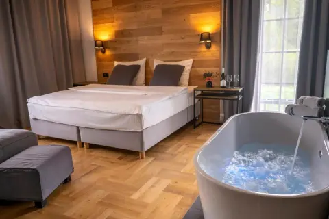 Przytulny pokój w hotelu w Bieszczadach z wanną z hydromasażem i wygodnym łóżkiem.