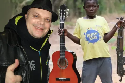 Mężczyzna w czarnym kapeluszu i chustce daje kciuk w górę. Obok chłopiec z gitarą i karabinem. Makumba tekst.