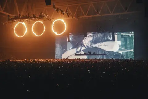 Koncert Swedish House Mafia Polska: płonące obręcze nad tłumem, na ekranie czuły uścisk.