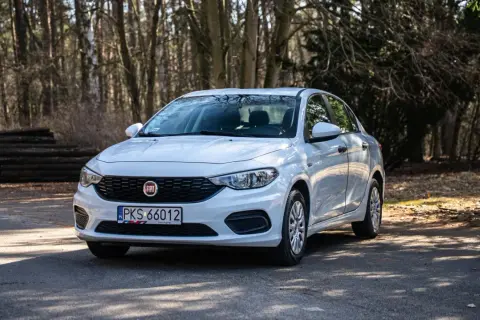 Biały Fiat Tipo na leśnej drodze. Wiele osób szuka fiat tipo opinie przed zakupem.