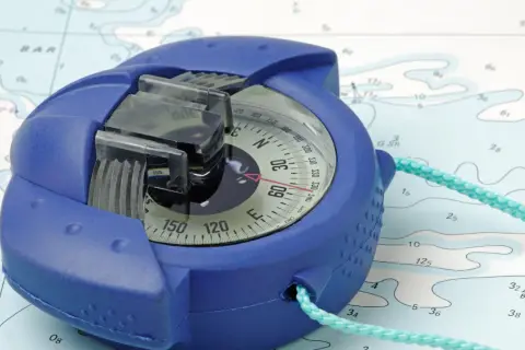 Una bussola blu su una mappa nautica, pronta per guidare l'avventura.