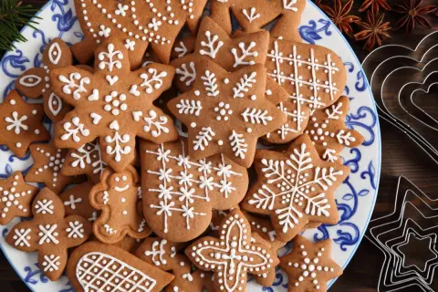 Talerz pełen pierniczków staropolskich (długodojrzewających) ozdobionych białym lukrem. Wśród nich gwiazdki, płatki śniegu i ludziki.