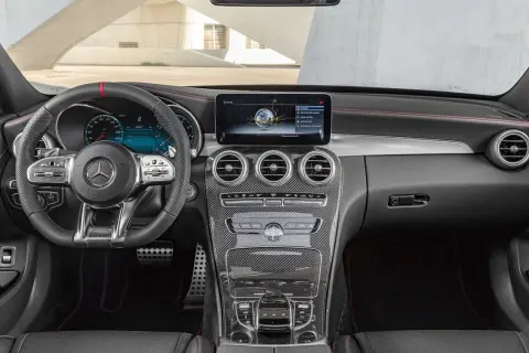 Interiör i en Mercedes W204 med sportratt, digital instrumentpanel och kolfiberdetaljer.