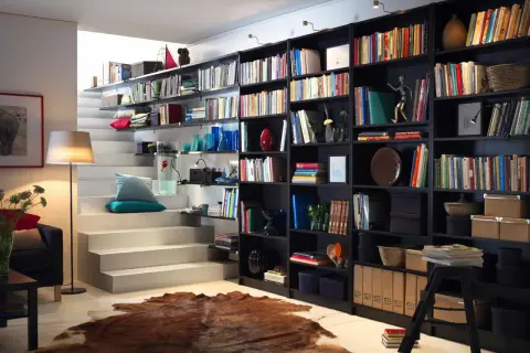 Estantería de libros negra con escaleras blancas. Las medidas estanteria libros son perfectas para este salón.