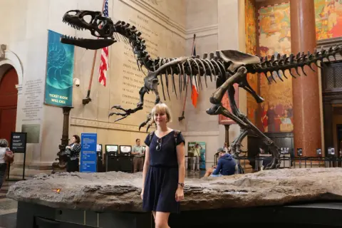 Kobieta pozuje przed szkieletem dinozaura w jednym z muzeów Nowego Jorku.