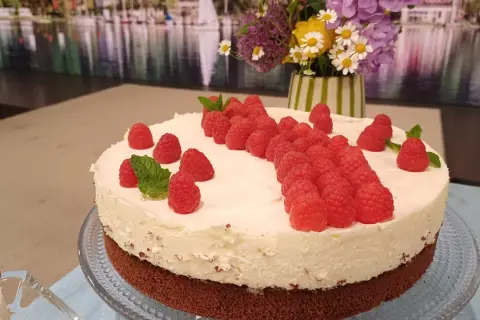Himbeer Mascarpone Torte mit frischen Himbeeren und Minze verziert, ein Genuss für Augen und Gaumen.