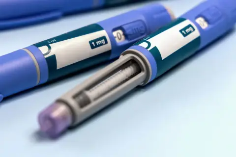 Dwa niebieskie peny z zielonymi etykietami z napisem "1 mg" i widocznym wkładem.