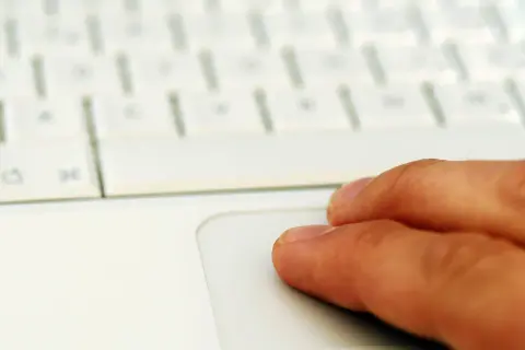 Finger auf einem weißen Laptop-Touchpad. Suche nach professionelle midifiles kostenlos für dein nächstes Musikprojekt.
