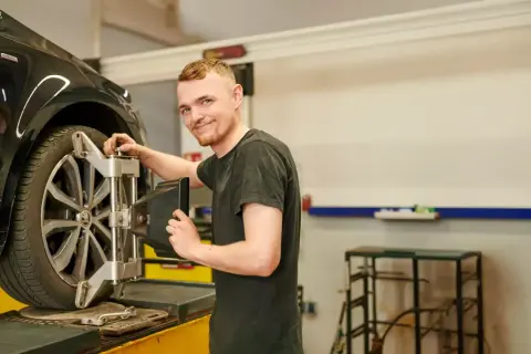 Mechaniker prüft die Spur am Auto.