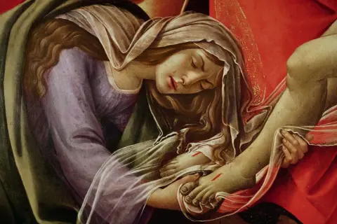 Detalle de una pintura: María Magdalena, con el rostro sereno, sostiene el pie de Cristo.