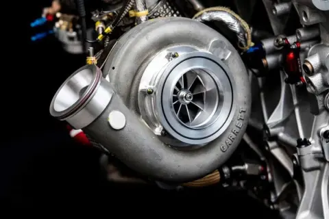 Detalle de un turbo Garrett en un motor de alto rendimiento. ¡Imagina la potencia que genera, porque todos los coches tienen turbo!