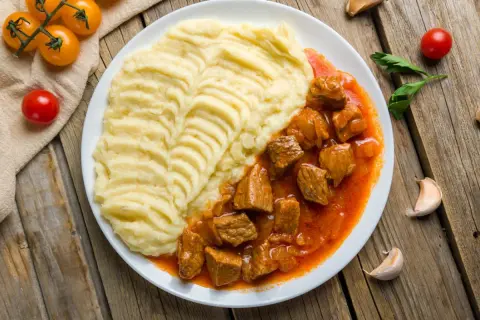 Gulasz wieprzowy z puree ziemniaczanym. Idealny na obiad, gdy zastanawiasz się, ile gotować gulasz wieprzowy, by był miękki.