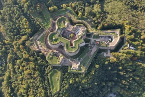 Fortyfikacje w kształcie gwiazdy otoczone lasem. Srebrna Góra oferuje unikalne atrakcje historyczne i widoki.