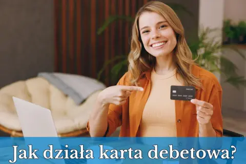 Uśmiechnięta kobieta pokazuje kartę debetową, wyjaśniając, co to jest karta debetowa i jak działa.