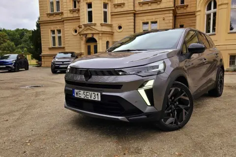 Szary Renault Symbioz przed zabytkowym budynkiem. Wiele osób szuka **Renault Symbioz opinie**, a ten model wygląda obiecująco.