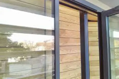 Fenêtre moderne avec bardage bois. Idéal pour **créer un volet intérieur** esthétique et fonctionnel.