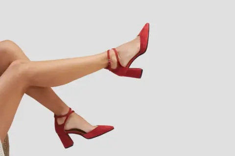 Scarpe rosse con tacco quadrato e cinturino alla caviglia. Il plateau scarpe significato è eleganza e comfort per ogni passo.