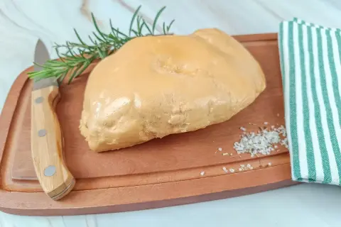 Un trozo de foie gras sobre tabla de madera, con romero, sal y un paño a rayas. La diferencia entre foie y foie gras es la preparación.