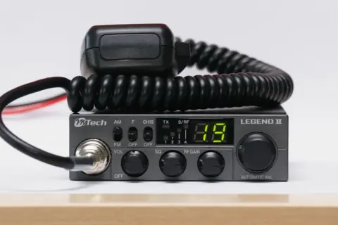 Szary radiotelefon CB MTech Legend II z mikrofonem na skręconym kablu.