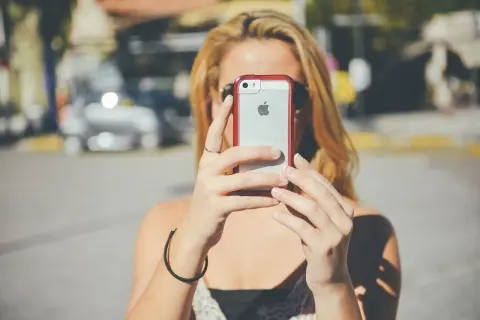 Blondynka z telefonem iPhone próbuje naprawić problem "nie zarejestrowano w sieci".