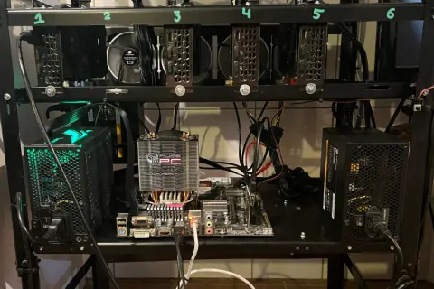 Rig do kopania kryptowaluty z sześcioma kartami graficznymi, płytą główną i zasilaczami.