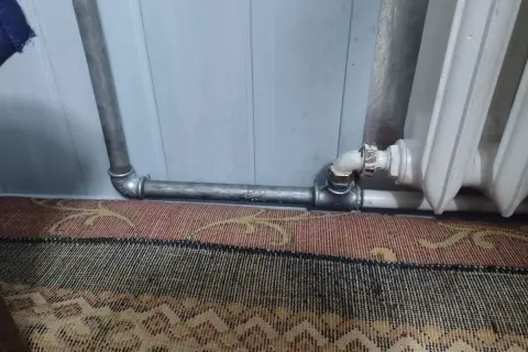 Instalacja grzewcza z metalowymi rurami, pokazująca, jak nagwintować rurę do podłączenia grzejnika.