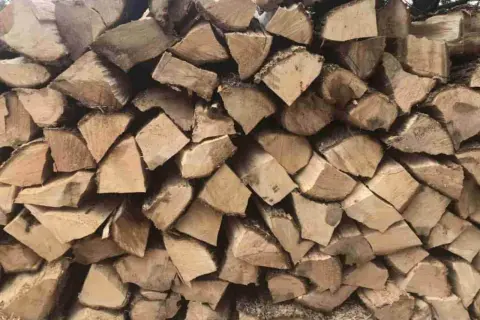 Stos drewna, idealny na czeremcha do kominka. Grube, suche kawałki drewna ułożone jeden na drugim, gotowe do rozpalenia ognia.