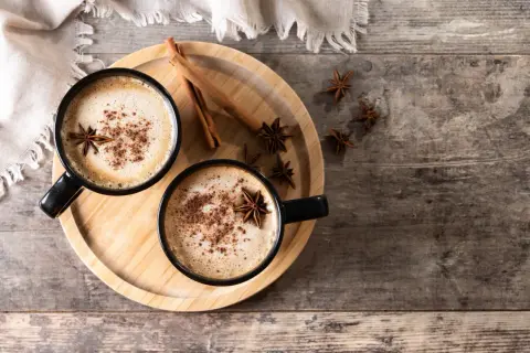 Deux tasses de latte épicé, garnies d'anis étoilé et de cannelle, parfaites pour une recette latte réconfortante.
