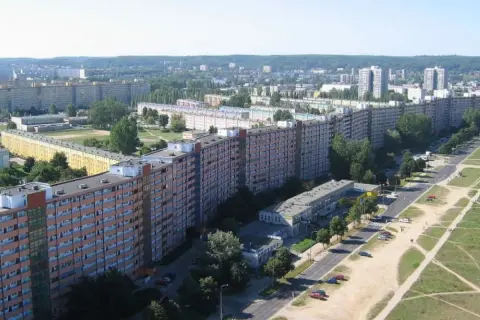 Widok z lotu ptaka na Falowiec w Gdańsku, pokazujący jego imponującą długość i rozciągający się wzdłuż ulicy i terenów zielonych.