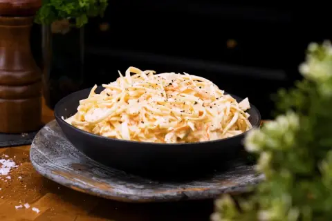 En skål med krämig, godaste coleslaw, toppad med nymalen svartpeppar. Perfekt tillbehör!