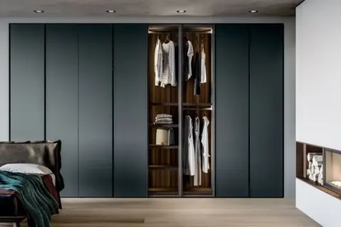 Armadio a muro con ante scorrevoli, che mostra l'interno con abiti appesi e ripiani. Le dimensioni armadio camera da letto sono perfette per un look moderno.
