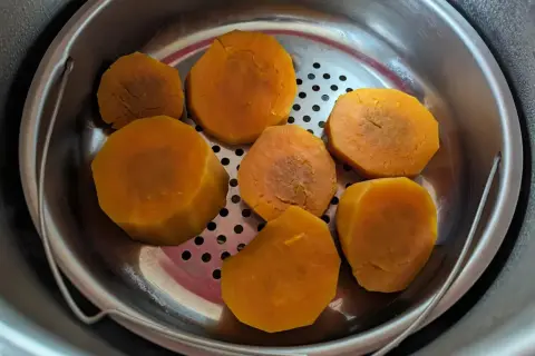 Morceaux de patates douces cuites à la vapeur dans un panier en métal, prêts pour une recette patate douce rapide.