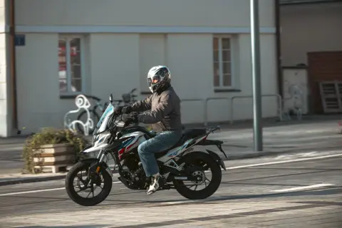 Mężczyzna w kasku jedzie na motocyklu Barton, który wygląda jak największy motocykl 125.