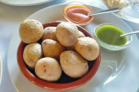 Pommes de terre canariennes salées servies avec une sauce mojo verde et une sauce rouge.